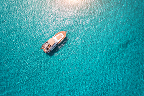 Aerial view of luxury yacht in transparent blue sea at sunny day in summer in Mallorca, Spain. Colorful landscape with boat, bay, clear azure water. Top view from air. Travel. Seascape with motorboat