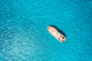 Aerial view of luxury yacht in transparent blue sea at sunny day in summer in Mallorca, Spain. Colorful landscape with boat, bay, clear azure water. Top view from air. Travel. Seascape with motorboat