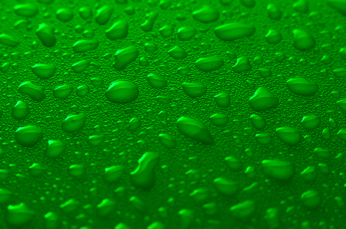 Green water drops background with yellow reflections.