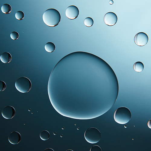 Transparent water drops with shadow on blue gradient background