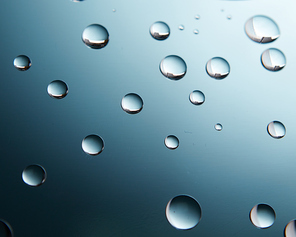 Beautiful small water drops on the glass on blue gradient background