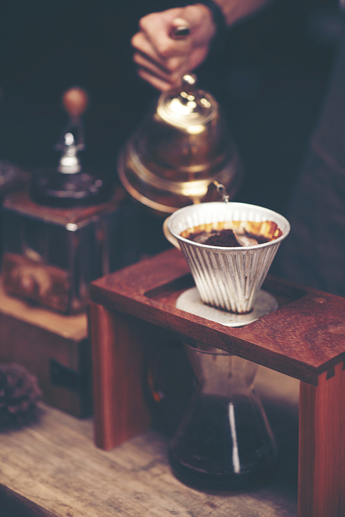 Close up of coffee brewing gadgets on wooden bar counter.