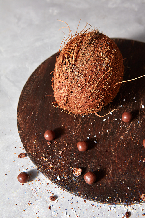 Whole organic coconut and chocolate balls on a wooden board is not snrrom kitchen table with copy space