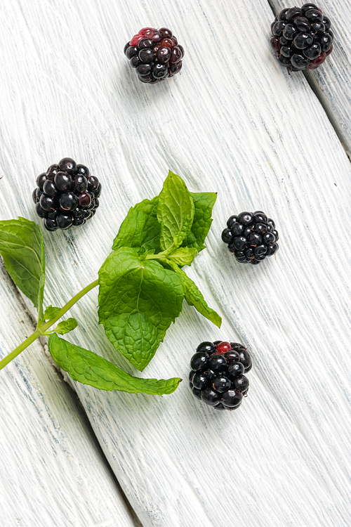 Blackberries on a old white painted wooden background.