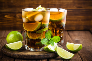 Cuba Libre cocktail with cola, lime and ice in glass, cold longdrink
