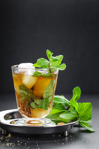 Mint Julep cocktail with bourbon, ice and mint in glass on black background