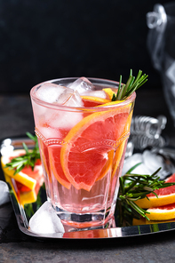 Grapefruit and fresh rosemary gin cocktail with juice, cold summer citrus refreshing drink or beverage with ice