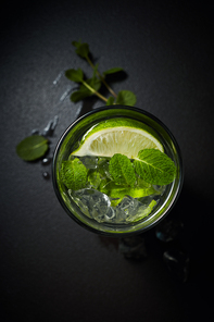Cold and refreshing lemonade or citrus cocktail with ice and mint overhead shot