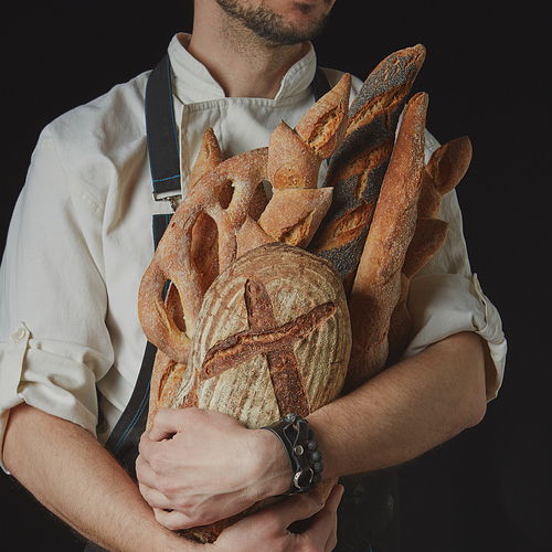Variety of bread in hands of baker