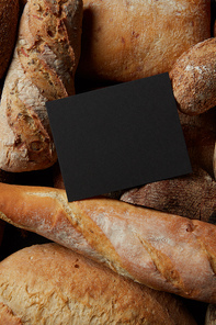 Top view of frame copy space of black color represented among different kinds of bread. Border of different bread sorts. Baking and cooking concept background.