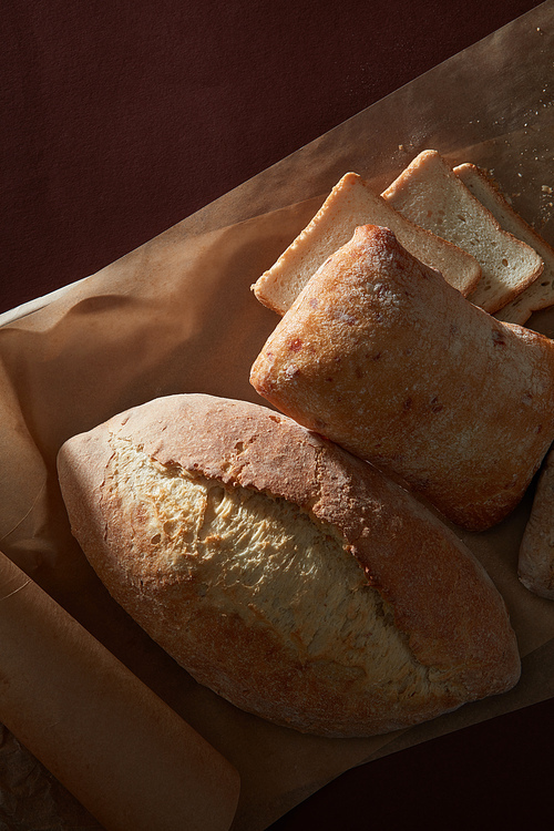 Close up view of Delicious fresh bread on baking paper with shadow