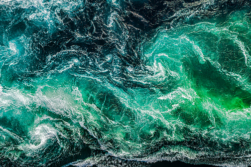 Abstract background. Waves of water of the river and the sea meet each other during high tide and low tide. Whirlpools of the maelstrom of Saltstraumen, Nordland, Norway