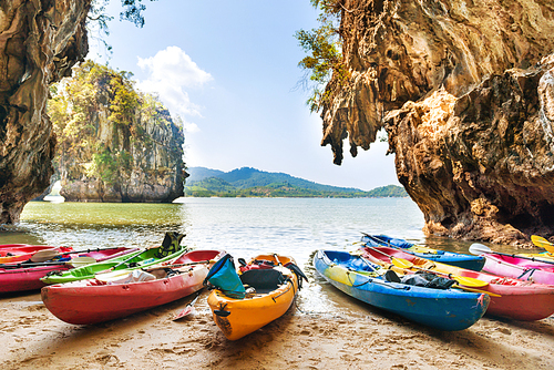 Colorful kayaks moored at sand beach at blue sea water near tropical islands