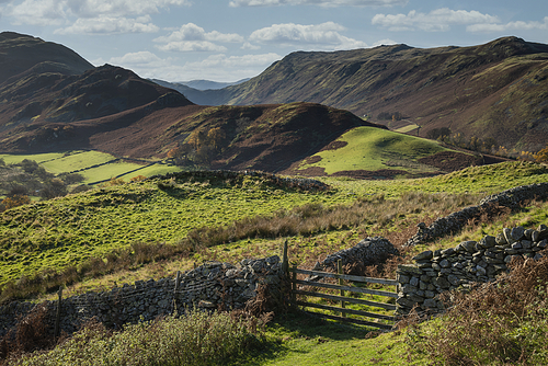 Epic Autumn Fall landscape image of Sleet Fell and Howstead Brow in Lake District with beautiful early morning light in valleys and on hills