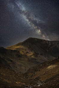 Beautiful epic digital composite landscape of Milky Way over Haystacks and High Stile in Lake District