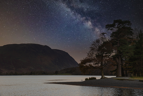 Beautiful epic digital composite landscape of Milky Way over Buttermere in Lake District
