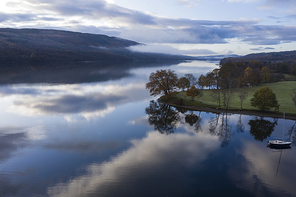 Stunning aerial drone landscape images over Coniston Water at sunrise on beautiful Autumn Fall morning