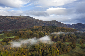 Stunning aerial drone landscape image from in the clouds looking down on hills and valleys on a beautiful Autumn Fall morning