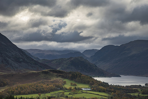 Epic sun beams light up Crummock Water in dramatic Autumn Fall landscape image with Mellbreak and Grasmoor
