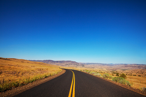 Road in the prairie country. Deserted natural travel background.