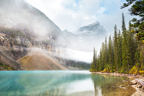 Serene scene by the mountain lake in Canada with reflection of the rocks in the calm water.