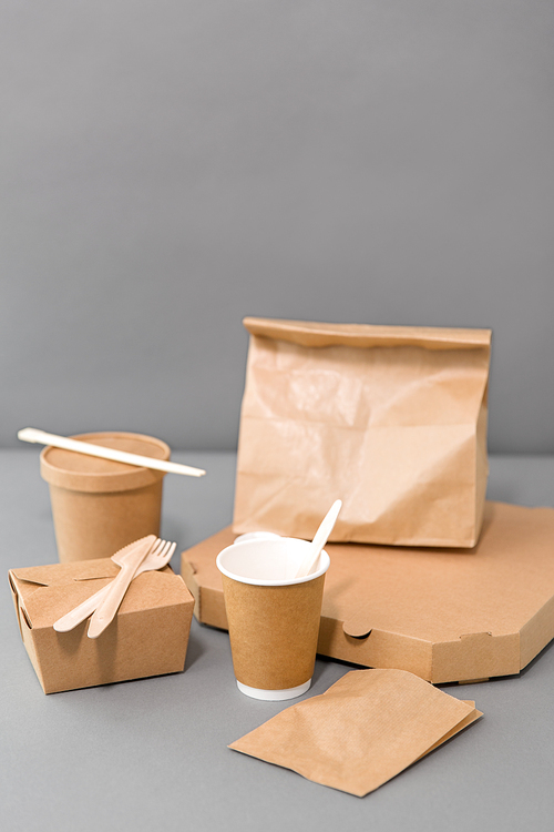 package, recycling and eating concept - disposable paper containers for takeaway food on table