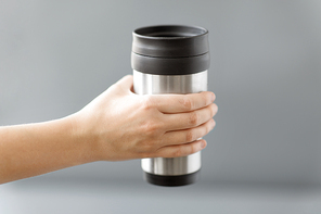 eco friendly concept - hand holding hot drink in tumbler mug or thermo cup