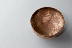 recycling, tableware and eco friendly concept - close up of coconut bowl on table
