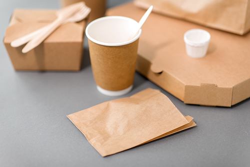 package, recycling and eating concept - disposable paper containers for takeaway food on table