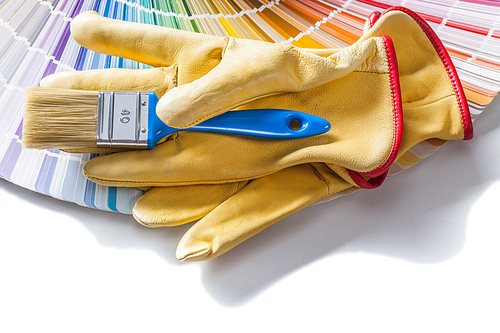 blue paintbrush and yellow gloves on color palette isolated