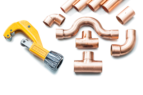 copper pipe and fittings with pipecutter isolated on white