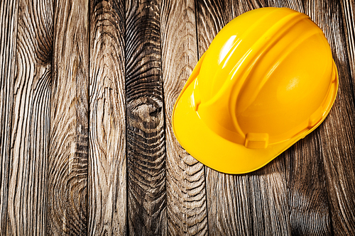 construction tools yellow helmet  on vintage wooden boards