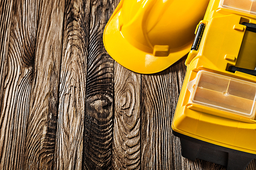 construction tools yellow helmet and toolbox very close up view on vintage wooden boards