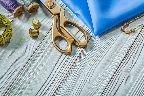 sewing tools on vintage white painted wood background