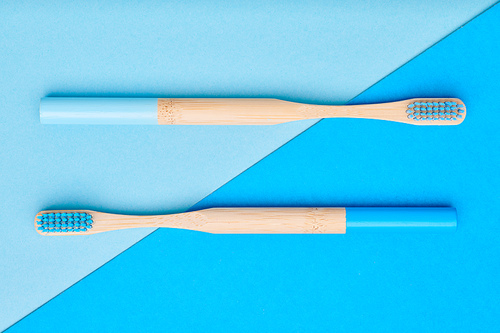 Toothbrushes on blue background top view. Tooth care, dental hygiene and health concept.