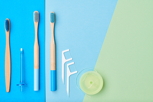 Toothbrushes and oral care tools over blue background top view copy space flat lay. Tooth care, dental hygiene and health concept.