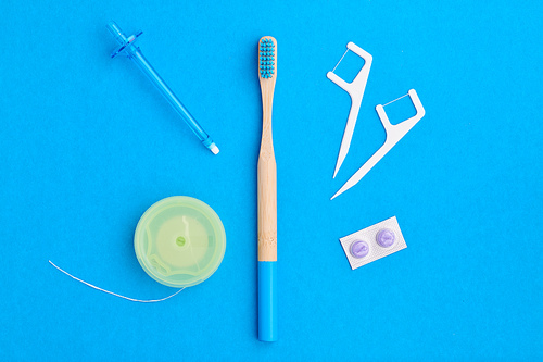 Toothbrush and oral care tools over blue background top view copy space flat lay. Tooth care, dental hygiene and health concept.