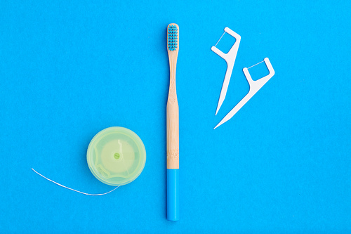 Toothbrush and oral care tools over blue background top view copy space flat lay. Tooth care, dental hygiene and health concept.