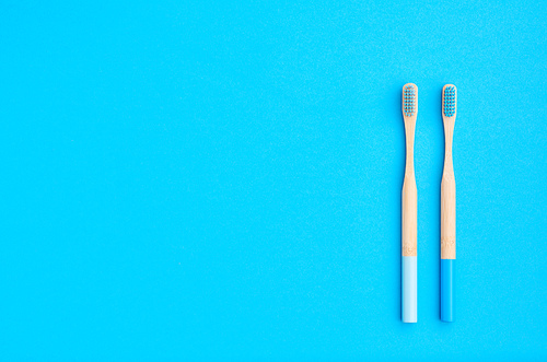 Toothbrushes on blue background top view copy space. Tooth care, dental hygiene and health concept.