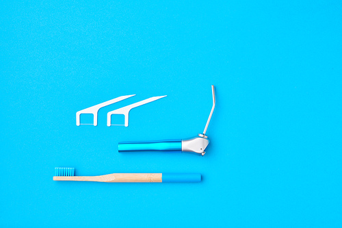 Dentist tools over blue background top view copy space flat lay. Tooth care, dental hygiene and health concept.