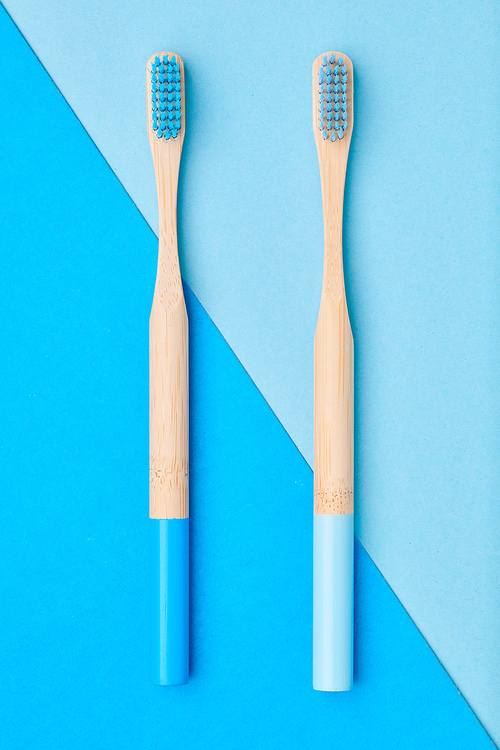 Toothbrushes on blue background top view. Tooth care, dental hygiene and health concept.