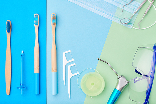 Dentist tools over blue background top view copy space flat lay. Tooth care, dental hygiene and health concept.