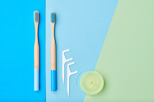 Toothbrushes and oral care tools over blue background top view copy space flat lay. Tooth care, dental hygiene and health concept.