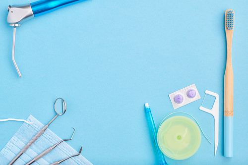 Dentist tools over light blue background top view copy space flat lay. Tooth care, dental hygiene and health concept.