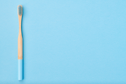 Toothbrush on light blue background top view copy space. Tooth care, dental hygiene and health concept.