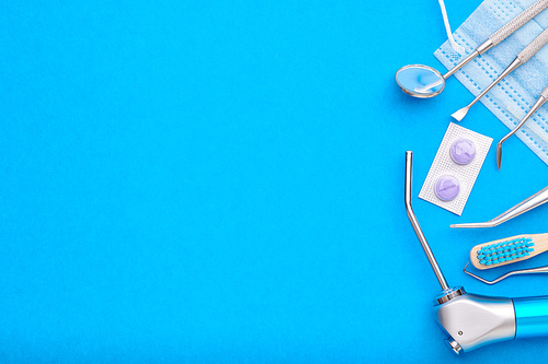 Dentist tools over blue background top view copy space flat lay. Tooth care, dental hygiene and health concept.