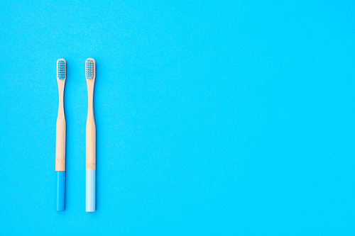 Toothbrushes on blue background top view copy space. Tooth care, dental hygiene and health concept.