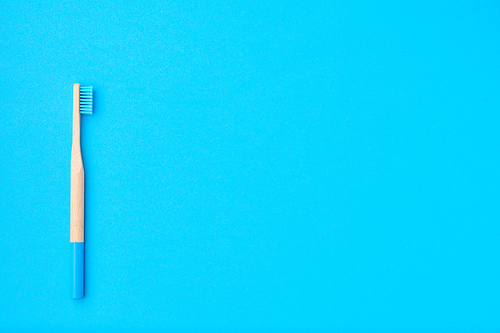 Toothbrush on blue background top view copy space. Tooth care, dental hygiene and health concept.