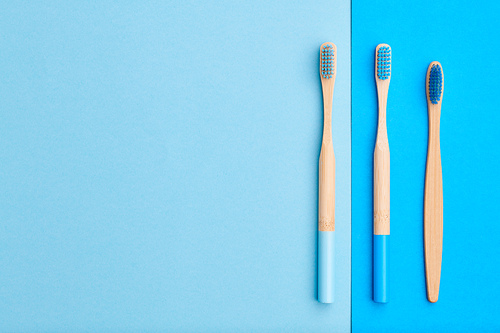 Toothbrushes on blue background top view copy space. Tooth care, dental hygiene and health concept.