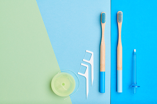 Toothbrushes and oral care tools over blue background top view copy space flat lay. Tooth care, dental hygiene and health concept.